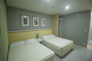 duas camas num pequeno quarto com duas camas sidx sidx em Twin Hearts Residences 1 em Roxas City