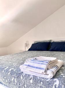 a white bedroom with a bed with blue and white blankets at APPARTAMENTO SFERISTERIO in Macerata