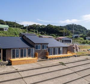 una casa con techo negro y ventanas en 日本海夕日ヴィラOne Story 