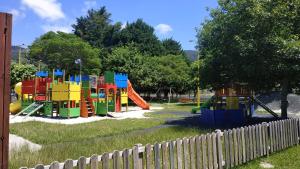 a playground in a park with a fence at Chalet Adosado in Moaña