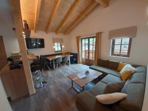 un salon avec un canapé et une table dans l'établissement Hochalmbahnen Chalets Rauris 1-15 WE2, Maislaufeldweg 1o OG, à Rauris