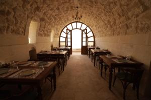 a dining room with tables and a large window at CEVHER KONAĞI in Halfeti
