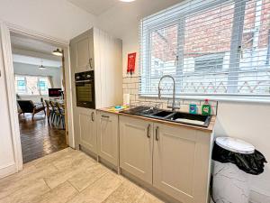 una cocina con fregadero y ventana en Central House with Pool Table, Free Parking, Super-Fast Wifi and Smart TV with Virgin TV and Netflix by Yoko Property, en Northampton 13 fotos más