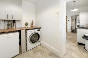 a kitchen with a washer and dryer in a room at Central House with Parking, Pool Table, Super-Fast Wifi and Smart TV with Virgin TV and Netflix by Yoko Property in Northampton