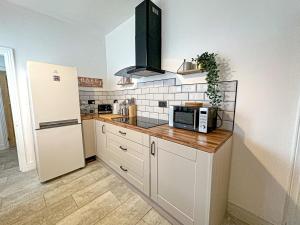 cocina con nevera y encimera con microondas en Central House with Pool Table, Free Parking, Super-Fast Wifi and Smart TV with Virgin TV and Netflix by Yoko Property, en Northampton