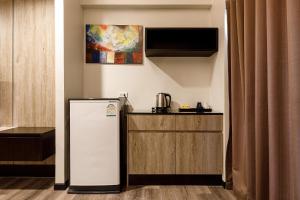 a kitchen with a refrigerator and a counter at Grand Marina Residence Hotel in Ban Laem Chabang