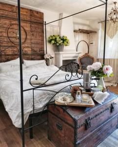 B&B CUCUTÍ في Ziano Piacentino: غرفة نوم مع سرير مظلة سوداء وطاولة خشبية