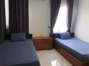 a bedroom with two beds and a window at Bening Asri Guesthouse in Gombolpaya