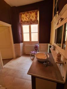 ein Bad mit einem Waschbecken und einem Fenster in der Unterkunft Maison Zola in Saint-Amand-Montrond
