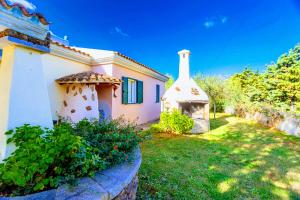 a small house with a yard with a fireplace at Orosei RE - Villa Osala - 800 m dal mare in Orosei