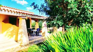 a porch of a house with a table and chairs at Orosei RE - Villa Osala - 800 m dal mare in Orosei