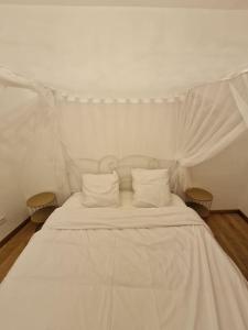 un letto bianco con lenzuola e cuscini bianchi di Maison Chic avec jacuzzi. UrbanSpa60 a Nogent-sur-Oise