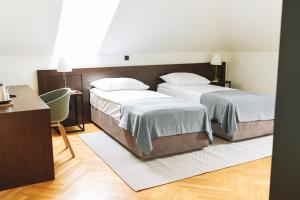 a bedroom with two beds and a desk and a chair at Dvorac Janković in Suhopolje