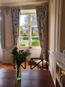 d'une salle à manger avec une table et une fenêtre. dans l'établissement Maison Zola, à Saint-Amand-Montrond