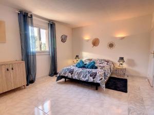 a bedroom with a bed with blue pillows on it at Villa Les Cyprés in Flayosc