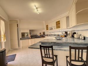 a large kitchen with two chairs and a counter at Villa Les Cyprés in Flayosc