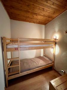 two bunk beds in a room with a wooden ceiling at RISOUL - Les Airelles - 6 à 8 couchages - Rue principale/ commerçante in Risoul