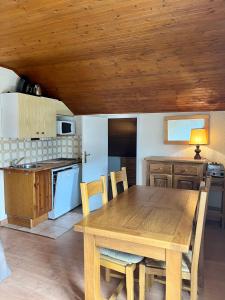 a wooden table in a kitchen with a wooden ceiling at RISOUL - Les Airelles - 6 à 8 couchages - Rue principale/ commerçante in Risoul