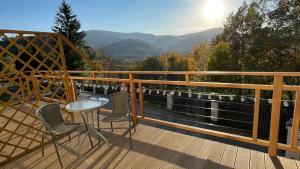 a table and chairs on a deck with a view at Dwupoziomowe Apartamenty Leszczyna in Ustroń +51 photos