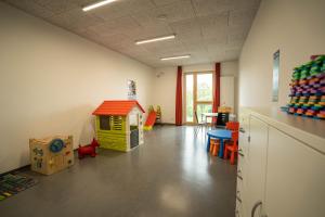 una habitación con una sala de juegos con una casa de juguetes en Jugendherberge Heilbronn en Heilbronn