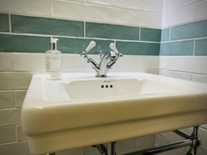 ein Waschbecken mit einer Seifenflasche drauf in der Unterkunft Priestley Cottage in Buxton + 31 Fotos