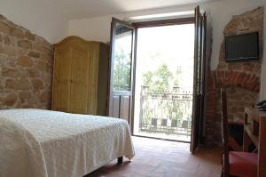 a bedroom with a bed and a large sliding glass door at Nascar Hotel in Santa Maria Navarrese