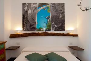a bedroom with a bed and two paintings on the wall at Nascar Hotel in Santa Maria Navarrese