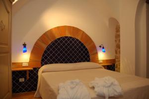 a bedroom with a bed with two towels on it at Nascar Hotel in Santa Maria Navarrese