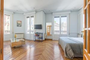 a bedroom with white walls and a bed and a wooden floor at Impresionantes vistas Skyline Madrid in Madrid