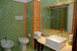 a bathroom with a sink and a toilet and a mirror at Nascar Hotel in Santa Maria Navarrese