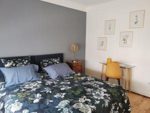 um quarto com uma cama com um edredão azul e branco em La Maison de Lucie - grande maison idéale en famille ou entre amis - jardin - parking gratuit em Sélestat