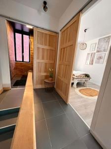 un pasillo con 2 puertas de madera y un banco en Homelove Spa en Neuilly-en-Thelle
