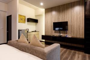 a living room with a couch and a flat screen tv at Grand Marina Residence Hotel in Ban Laem Chabang