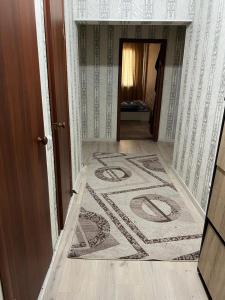 einen Flur mit einem Teppich auf dem Boden in einem Haus in der Unterkunft 2 х комнатная квартира in Schymkent