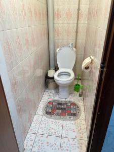 ein Bad mit WC und Fliesenboden in der Unterkunft 2 х комнатная квартира in Schymkent