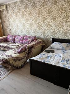 Zimmer mit 2 Betten und einem Sofa in der Unterkunft 2 х комнатная квартира in Schymkent