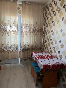 Zimmer mit einem Bett und einem Fenster mit Vorhängen in der Unterkunft 2 х комнатная квартира in Schymkent