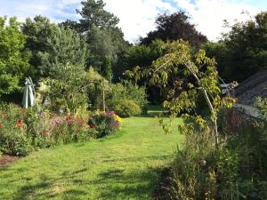 um jardim com flores e árvores e um relvado em The White House em Milton Keynes