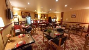 a restaurant with tables and chairs in a room at Hôtel 1er Consul Rouen in Rouen
