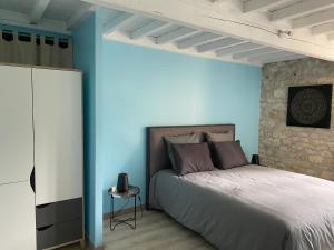 um quarto com uma cama e uma parede azul em La Caza du quercy em Cazes-Mondenard