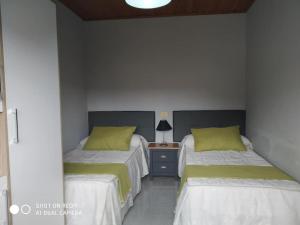 Dos camas en una habitación con mesita de noche. en Apartamento con terraza y vistas al mar, en Bueu