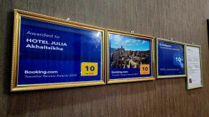 tres letreros colgando de una pared en una oficina en HOTEL JULIA Akhaltsikhe, en Akhaltsikhe