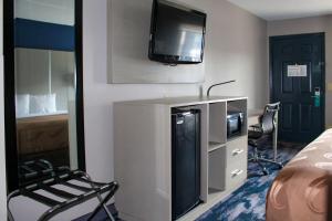a hotel room with a tv and a bed and a chair at Quality Inn Scottsboro US/72-Lake Guntersville Area in Scottsboro