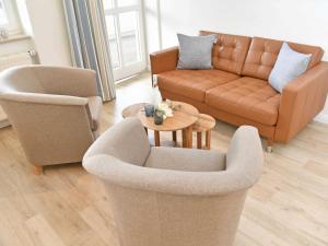 un soggiorno con 2 sedie, un divano e un tavolo di Villa Freya - Apt. 01 a Ostseebad Sellin