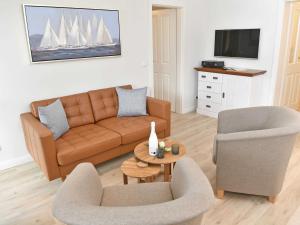 un soggiorno con divano, 2 sedie e TV di Villa Freya - Apt. 01 a Ostseebad Sellin