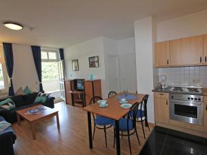 een keuken en een woonkamer met een tafel en stoelen bij Villa Freya - Apt. 04 in Ostseebad Sellin