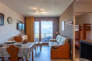 a living room with a couch and a table at Le Corbier de Colette in Villarembert