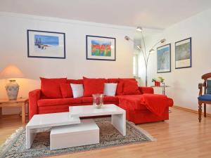 uma sala de estar com um sofá vermelho e uma mesa em Villa Freya - Apt. 06 em Ostseebad Sellin