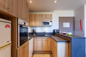 a kitchen with wooden cabinets and a counter top at Le Corbier de Colette in Villarembert +7 photos