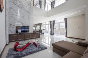 ein Wohnzimmer mit einem Sofa und einem Tisch in der Unterkunft Luxury Pool Villa at Golden Sea Hua Hin in Hua Hin